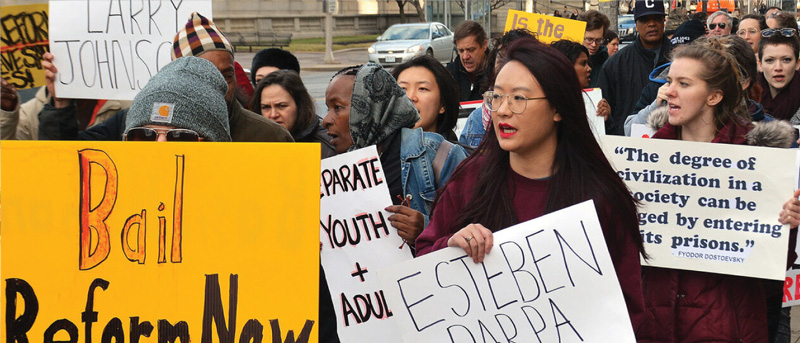 A bunch of people with peaceful protest signs in the street.