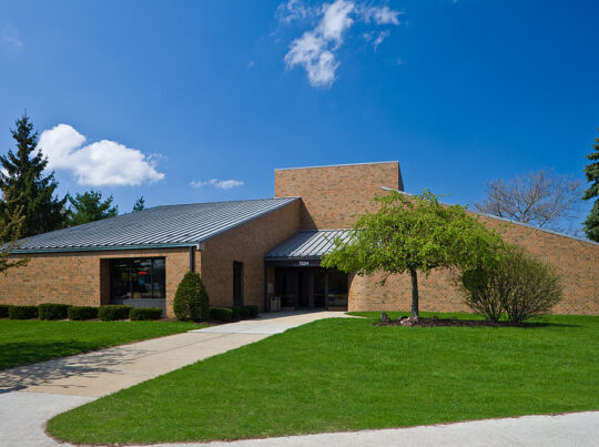 Exterior of the Fleet Building with a 50 foot sidewalk leading to its entrance