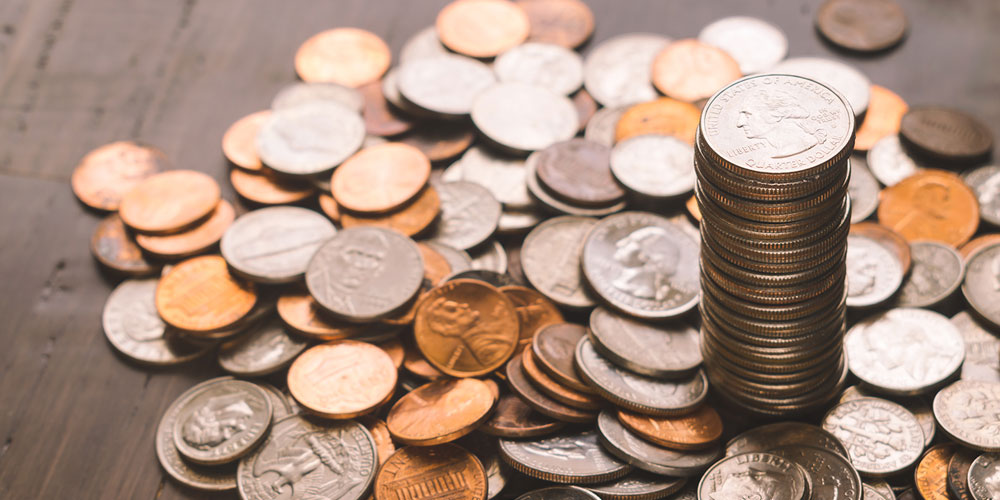 Lots of coins on a table and a stack of quarters