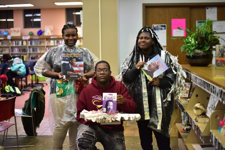 Three teens wearing outfits made of newspaper