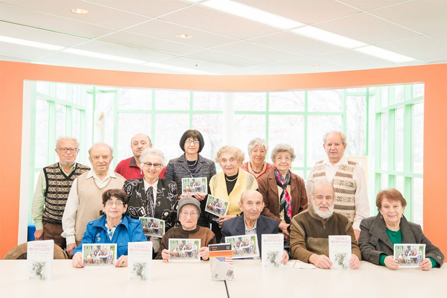 Group of people at a table holding books